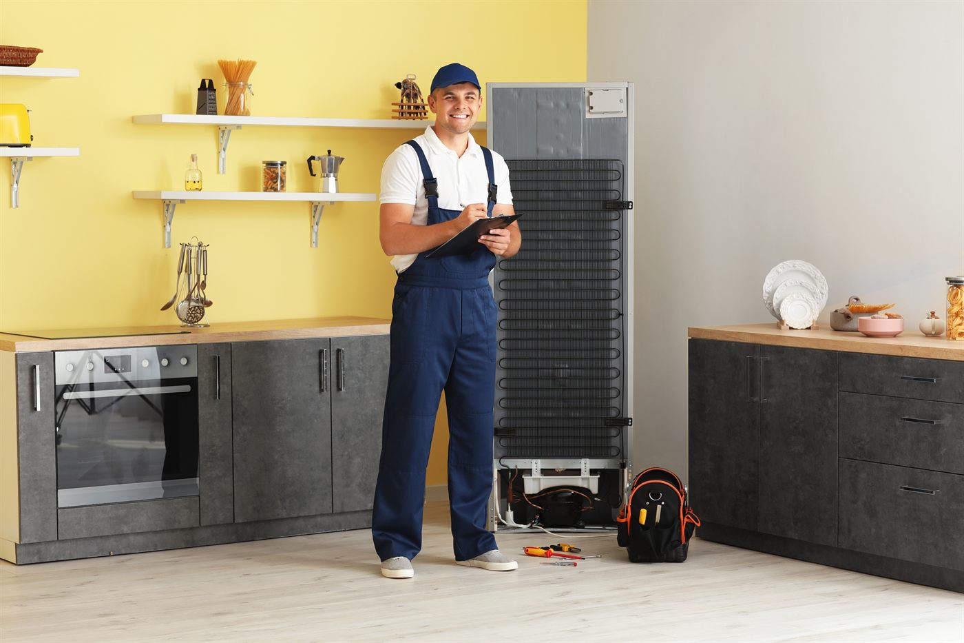 Tehnician repară un frigider care curge apă
